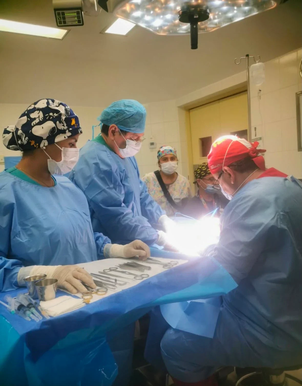 El Dr. Achá operando junto al equipo quirúrgico bajo la lámpara de quirófano