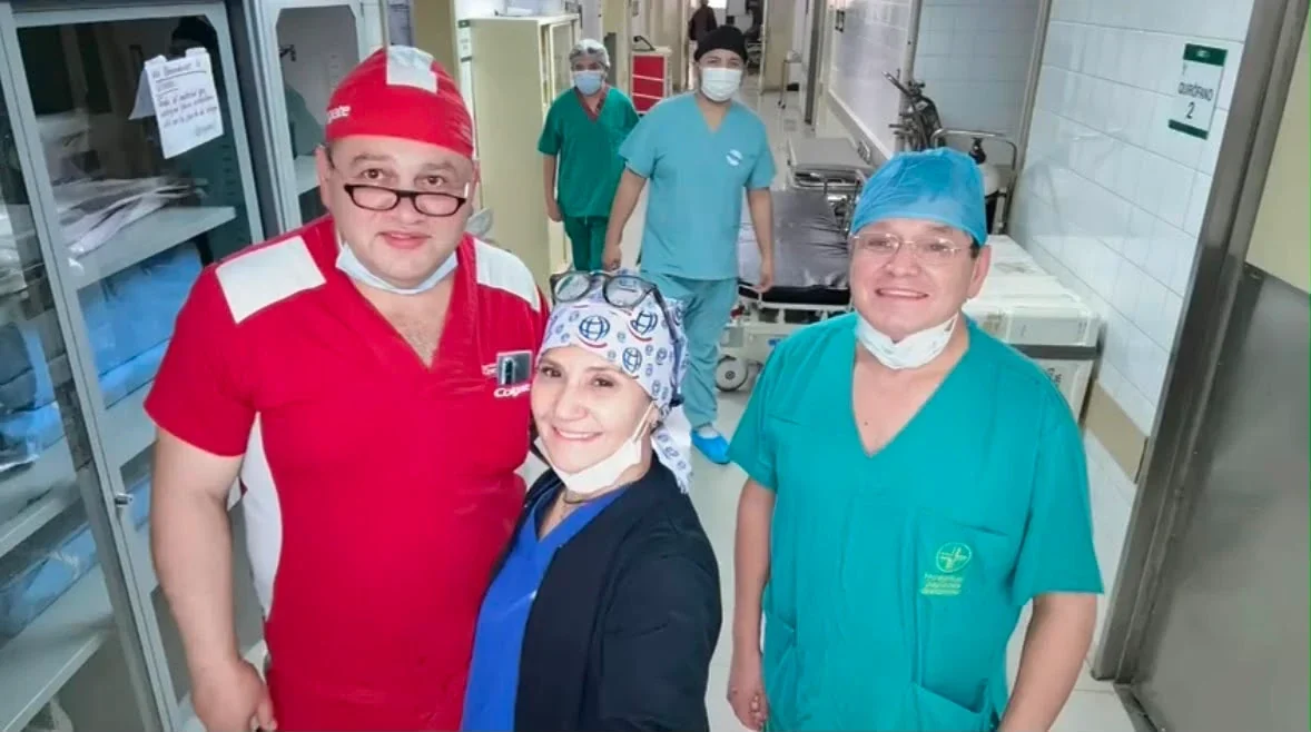 El Dr. Achá con dos colegas en el pasillo de quirófanos de un hospital