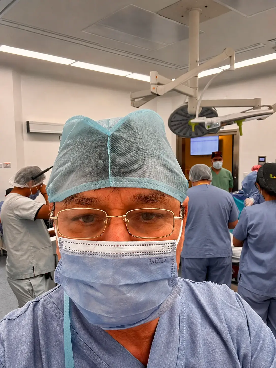 El Dr. Achá con gorro y barbijo quirúrgicos dentro del quirófano